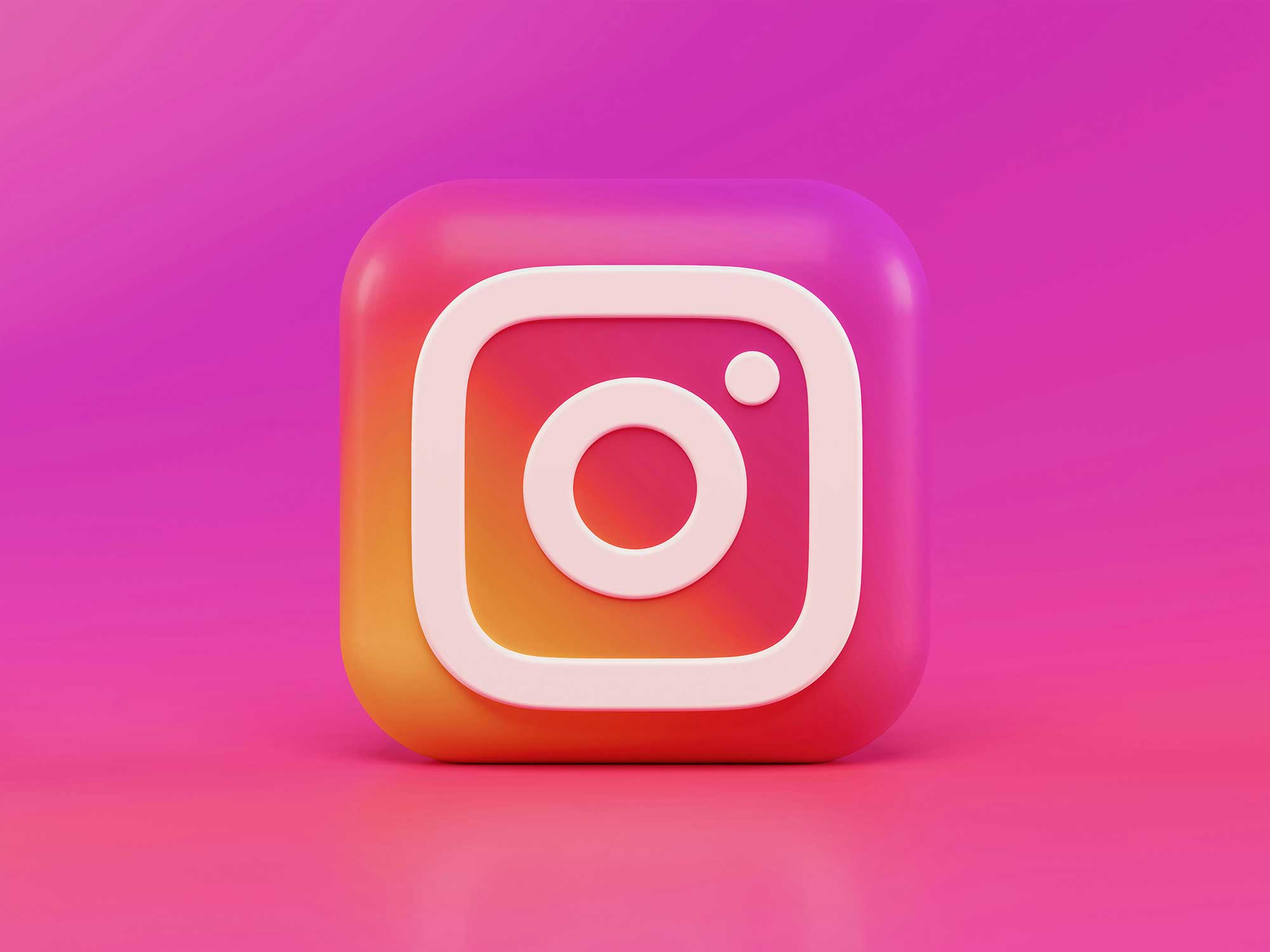 Instagram's logo in 3D with a pink background.