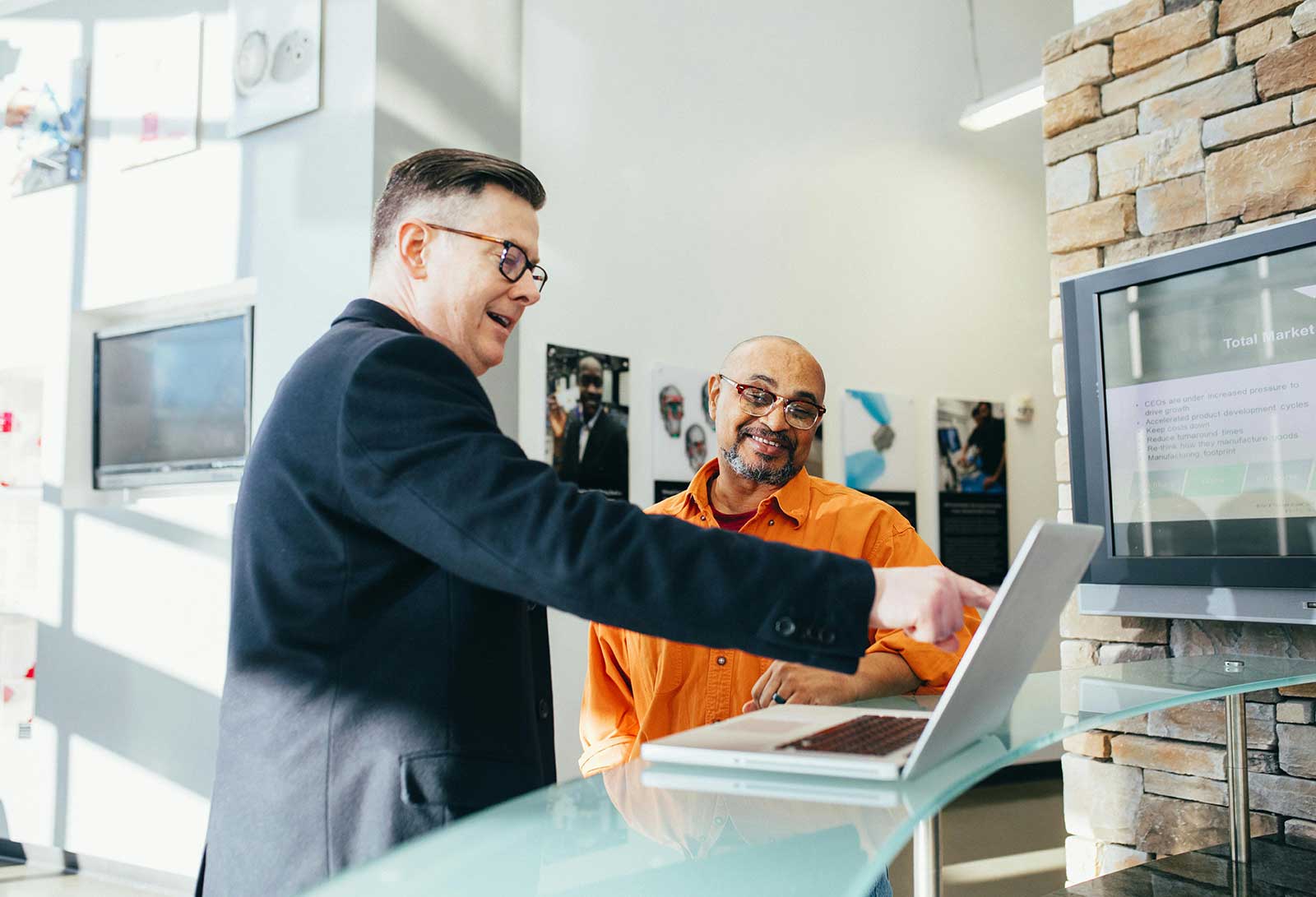 pexels-linkedin-2182981 A managing partner at a Cleveland marketing agency shows a Cleveland business owner an AI service on a laptop.